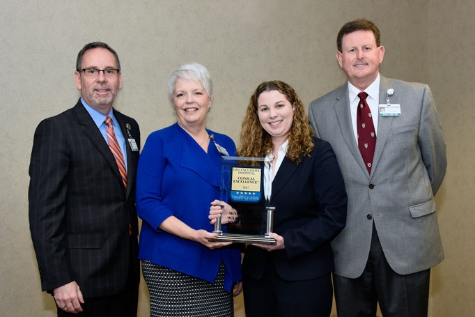 McLeod officials holding a Healthgrades trophy recognizing it as one of the top hospitals in the United States.