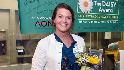Beth Gleason, a staff nurse in the Trauma Surgical Care Unit, posing with McLeod Heath's DAISY Award