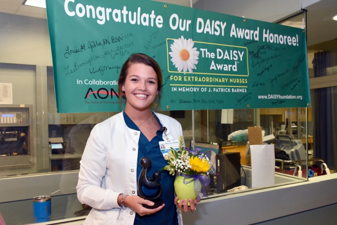 Beth Gleason, a staff nurse in the Trauma Surgical Care Unit, posing with McLeod Heath's DAISY Award