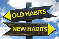 A sign pointing to old habits and sign pointing the opposite direction towards new habits