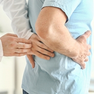 A doctor touching the lower back of a patient