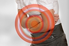 A woman with her arms crossed over her stomach and a red bullseye indicating pain