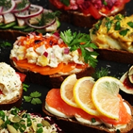 A table full of fish, vegetables, whole grain breads and fruit.