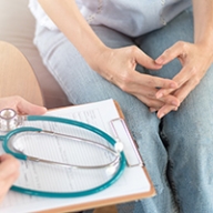 A doctor filling out a form with a female patient