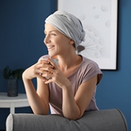 A female cancer patient smiling while wearing a head wrap