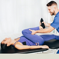 A woman's legs being stretched by a male doctor