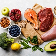 A display of healthy food items like fruit, vegetables, nuts and fresh meat.