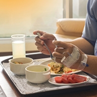 A patient in a hospital eating a prepared meal