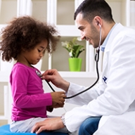A little girl being examined by a pediatrician