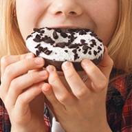 A young child eating a sugary donut