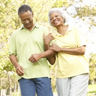 A man and a woman walking arm in arm outside.