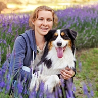 A woman holding a collie-like dog