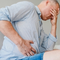 A man holding the side of his stomach in pain